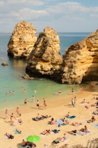 Explore the stunning cliffs and turquoise waters of Praia do Camilo beach in Lagos, Portugal, a perfect summer retreat.