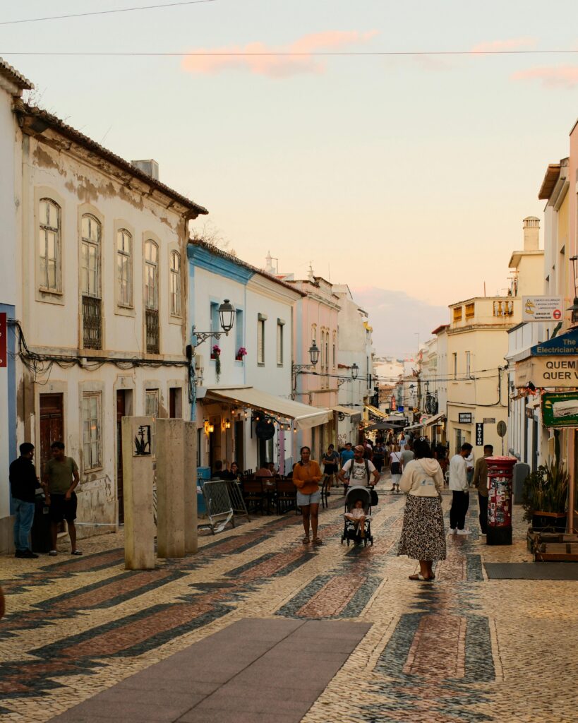 Explore the evening charm of Lagos, Portugal's cobblestone streets and pastel buildings during golden hour.
